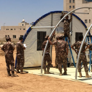 Jordanian soldiers assemble a BLU-MED Field Hospital's high-strength metal frame during installation. 