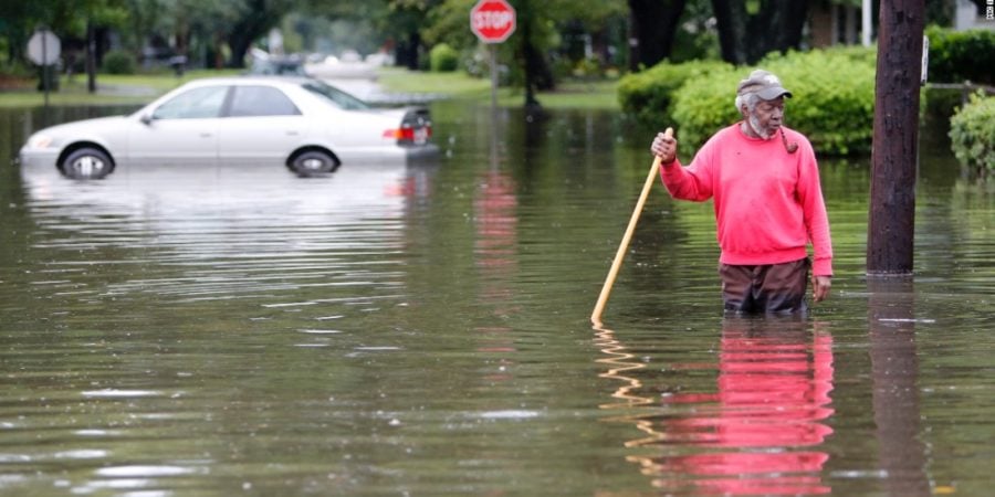 Man standing knee deep in flood water