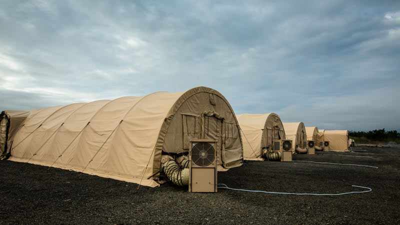 row of brown emergency medical response tents in lot